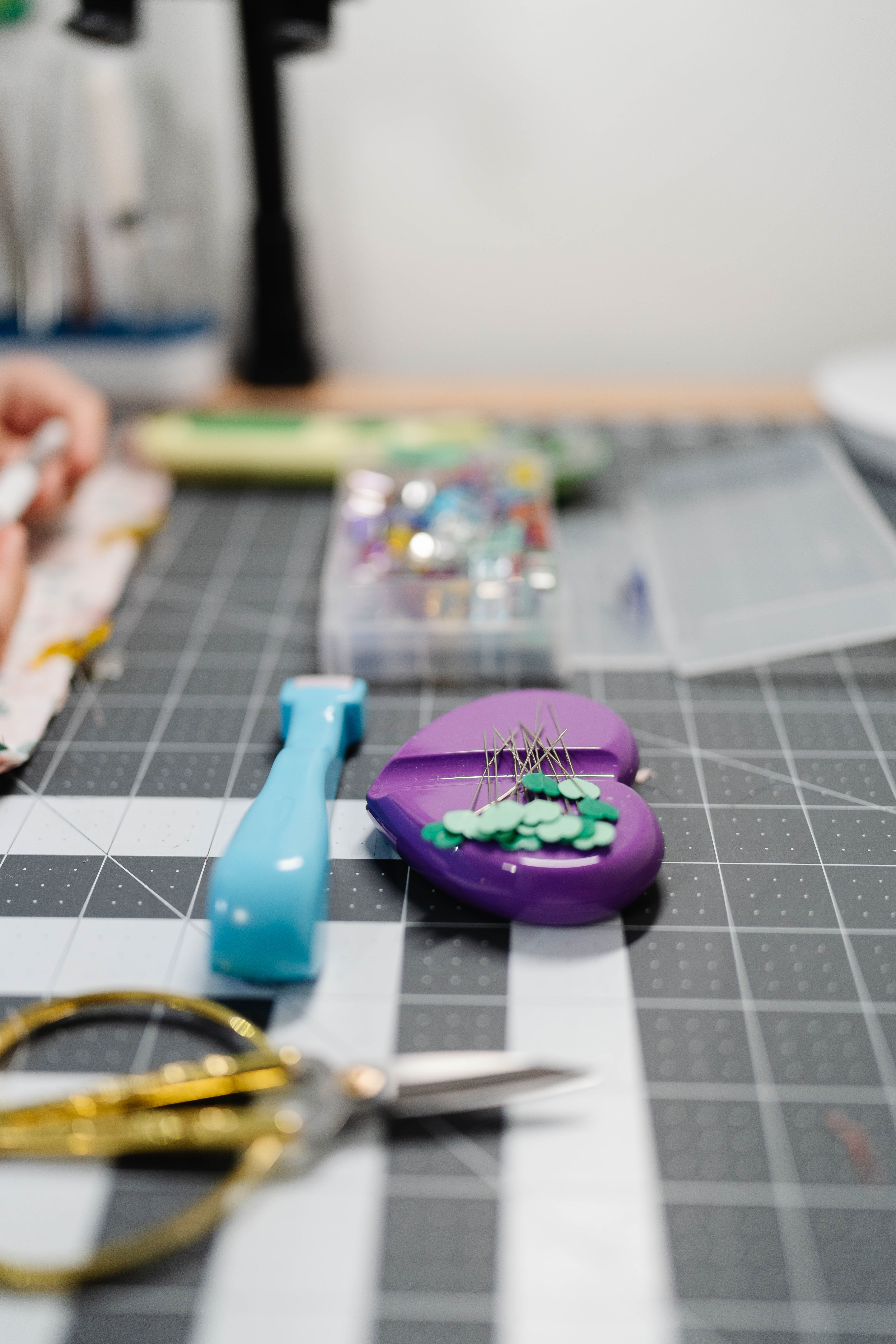 Happy Stitches sewing project supplies for a Crayon Wrap Roll, including fabric pieces, Clover Hot Ruler, Rotary Cutter, Heart-Shaped Pins, Wonder Clips, and Roll & Press