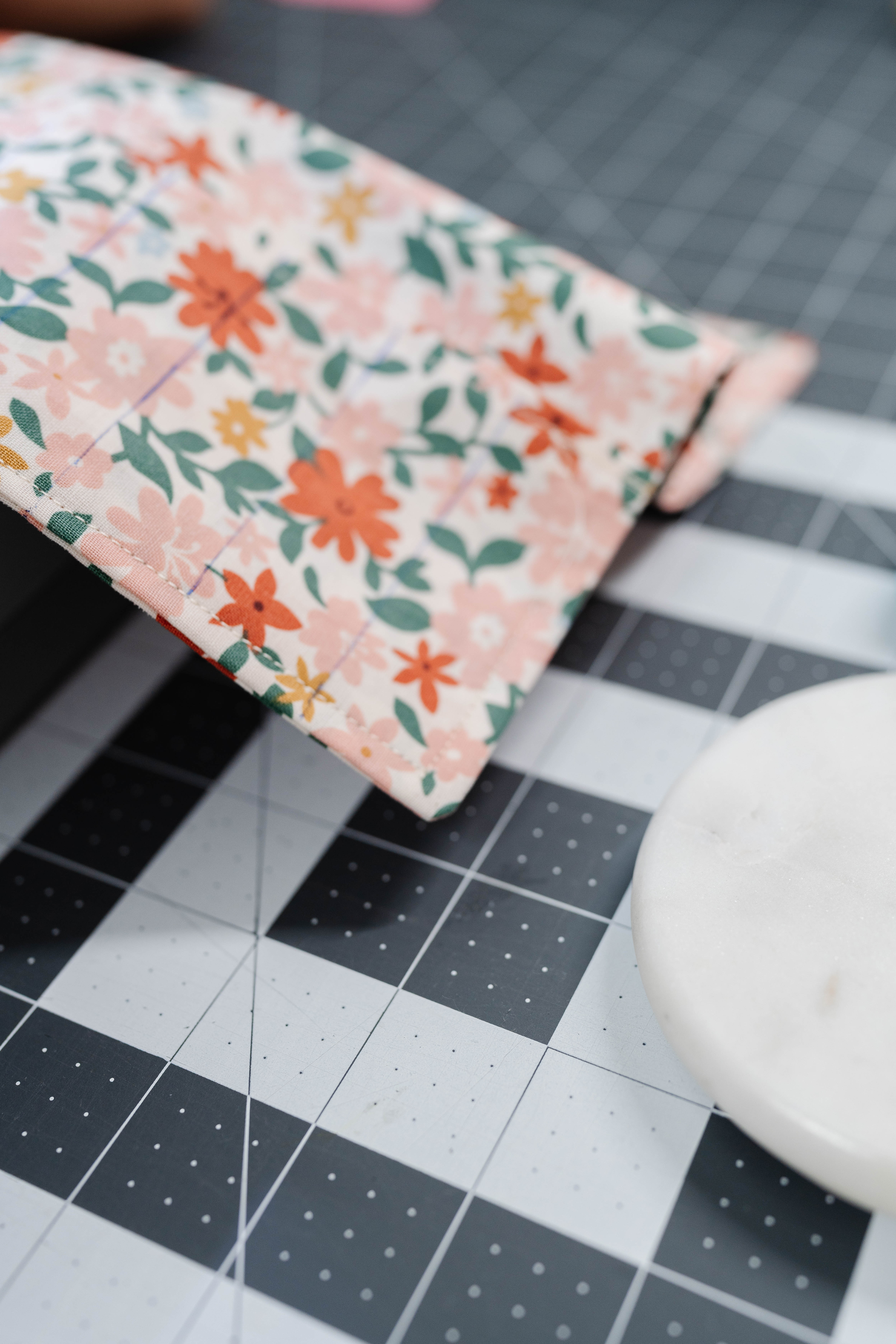 Happy Stitches sewing project supplies for a Crayon Wrap Roll, including fabric pieces, Clover Hot Ruler, Rotary Cutter, Heart-Shaped Pins, Wonder Clips, and Roll & Press