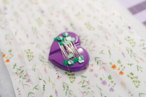 Girl holding handmade green gingham iPad sleeve sewn with Clover tools and pink flower button